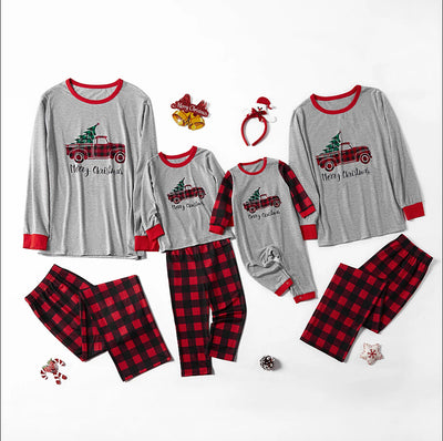 Family of four wearing matching gray long-sleeve pajamas with red truck and Christmas tree graphic, red and black plaid pants. - Image 6