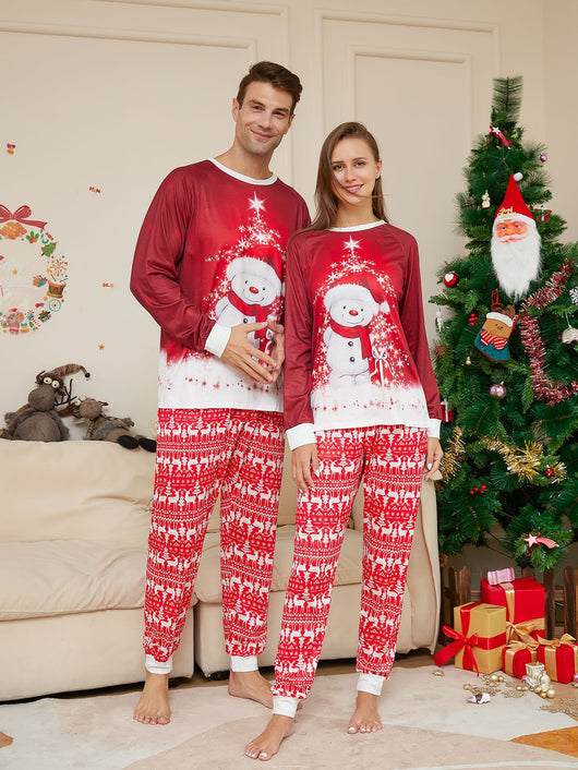 Family of four wearing matching red Christmas pajamas with snowman tops and reindeer fair isle pants, sitting by a Christmas tree. - Image 5