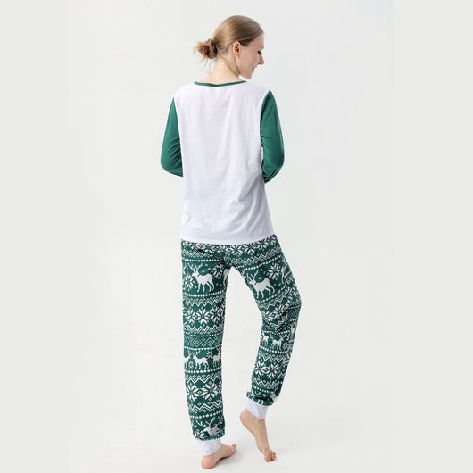 Woman in a Christmas pajama set with a white top, green sleeves, dinosaur graphic, and green fair isle pants. - Image 17