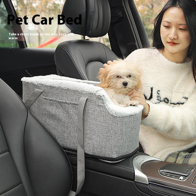 Grey pet car seat with plush white lining, designed for small dogs or cats, placed on a car's center console.