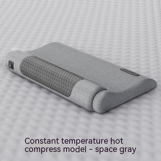 Dark gray cervical spine pillow with light gray textured massage area and power button on a light gray surface. - Image 6
