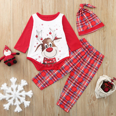 Red and white family Christmas pajamas with a reindeer graphic on the tops and red plaid pants, including a baby romper and hat.