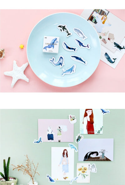 Box of 'Lifelog sticker' whale stickers with various blue whale designs scattered on a light blue plate. - Image 8