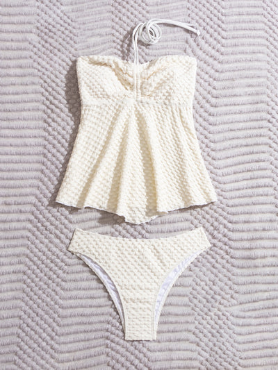 Off-white textured two-piece women's swimsuit with a bandeau halter top and high-cut bottoms, displayed with a straw hat and sunglasses. - Image 13
