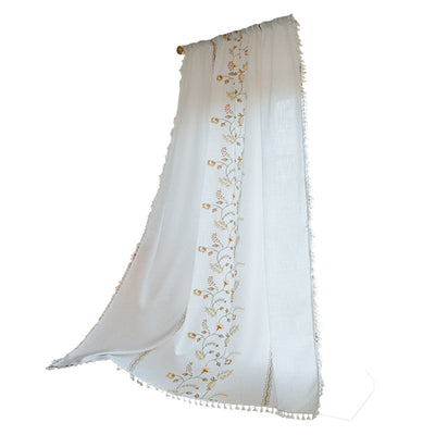 White semi-sheer curtain with brown botanical embroidery and white tassels, draped over a small wooden table. - Image 5
