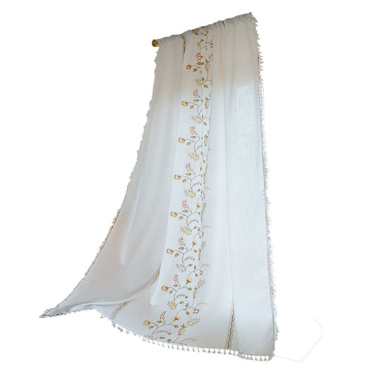 White semi-sheer curtain with brown botanical embroidery and white tassels, draped over a small wooden table. - Image 5