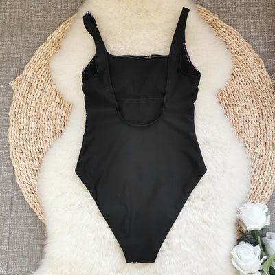 Black one-piece swimsuit for women featuring a vibrant multi-color print with dragons, suns, moons, and stars. - Image 8