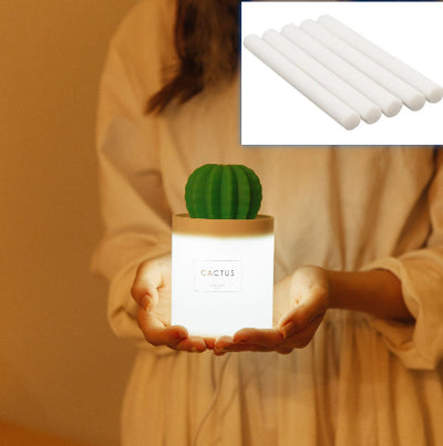 Person holding a glowing white cactus humidifier with a green top; inset shows five white humidifier filter sticks. - Image 7