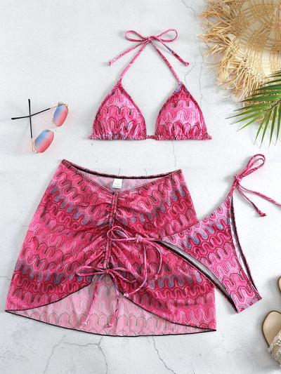 Three-piece printed swimsuit with a red and teal abstract pattern, featuring a halter bikini top, bottom, and mesh wrap skirt with drawstring. - Image 3