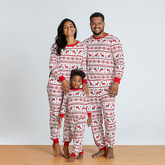Family wearing matching white and red Christmas pajamas with elk and snowflake patterns, including a baby and a dog. - Image 3