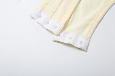 White halter monokini with deep V-neck, side cut-outs, and pearl bead embellishments on a woman at the beach. - Image 37