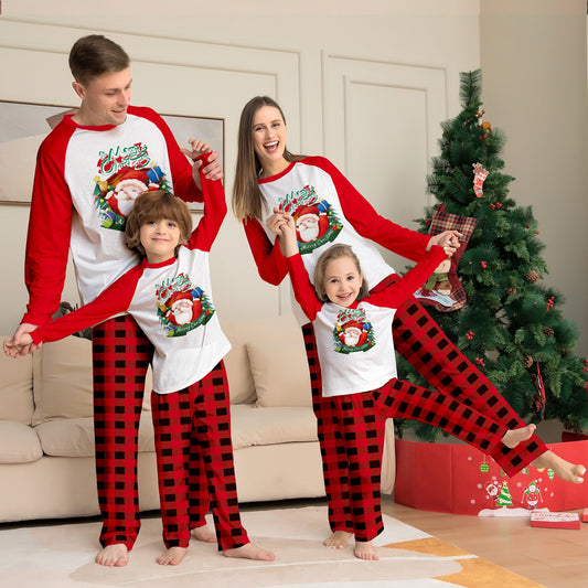 Man in a red and white Christmas pajama set with a Santa Claus graphic top and red and black plaid pants.