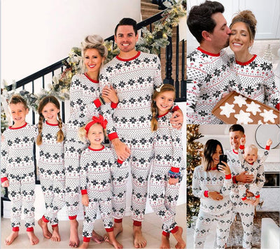 Family of six wearing matching black, white, and red fair isle print Christmas pajamas with red cuffs and collars. - Image 2