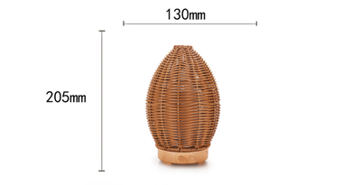 Hollow rattan aroma diffuser with an egg-shaped woven brown exterior and a light wood-grain base. - Image 7