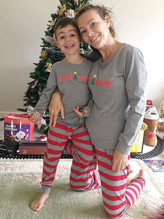 Family of four in matching grey long-sleeve tops and red striped pants, posing in a festive holiday setting. - Image 9