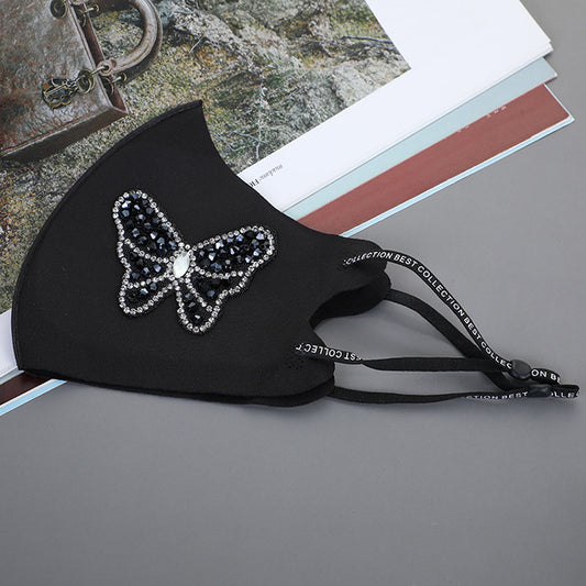 Black ear-mounted mask with a sparkling rhinestone bow pattern, featuring adjustable ear loops. - Image 2