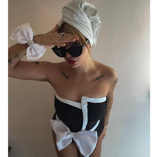 Black and white color-block one-piece swimsuit with an irregular tube top and a large white bow, paired with a matching pencil skirt. - Image 9