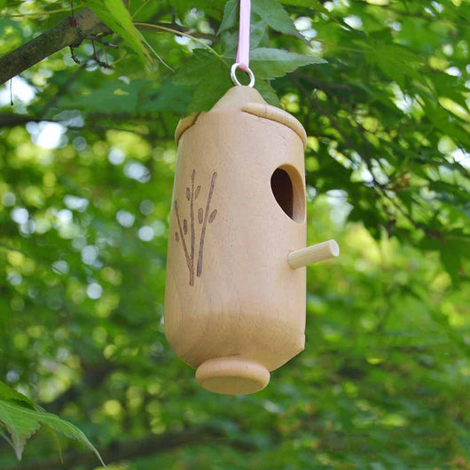 Light brown wooden birdhouse with a conical roof, circular entrance, perch, and etched branch design, hanging hook. - Image 2