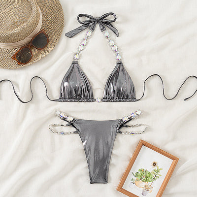 Shiny blue two-piece bikini with rhinestone-embellished halter top and high-cut bottom, laid flat with a straw hat and sunglasses. - Image 6