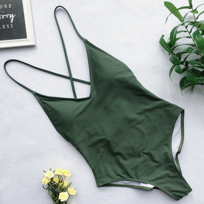 Light blue backless one-piece swimsuit with thin straps, made of polyester, laid flat on a wooden surface. - Image 8
