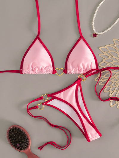 Pink and red halter-style triangle bikini with heart-shaped hardware and tie-up thong bottom, worn on a beach. - Image 17