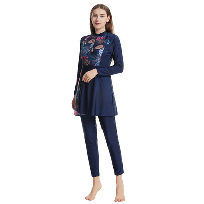 Woman in a navy blue quick-drying conservative swimwear set with a tropical leaf print tunic and matching swim cap. - Image 11