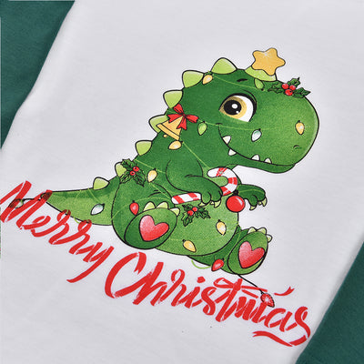 Woman in a Christmas pajama set with a white top, green sleeves, dinosaur graphic, and green fair isle pants. - Image 32