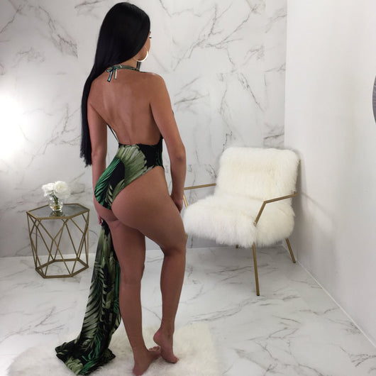 Woman in a black one-piece swimsuit with green leaf print, plunging V-neck, and matching sheer sarong cover-up. - Image 8