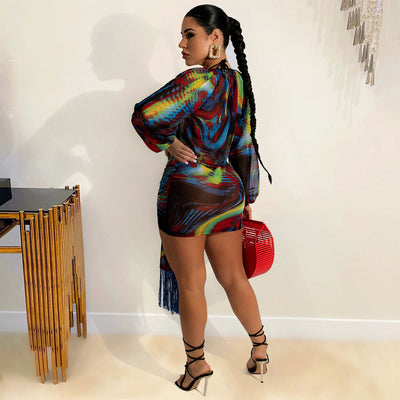 Model wearing a blue, red, and yellow abstract print three-piece mesh swimsuit set with a bikini top, mini skirt, and long-sleeve cover-up. - Image 12