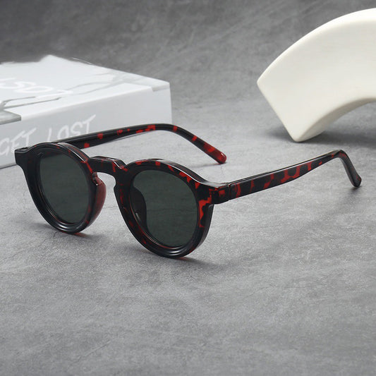 Vintage round frame sunglasses with black frames and pink lenses on a gray surface. - Image 2