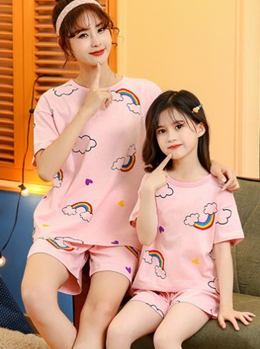 Mother and daughter wearing matching pink cotton short-sleeved pajama sets with rainbow and cloud patterns. - Image 4