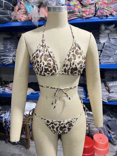 Woman in a light blue patterned triangle bikini with tie-side bottoms on a sandy beach with palm trees. - Image 9