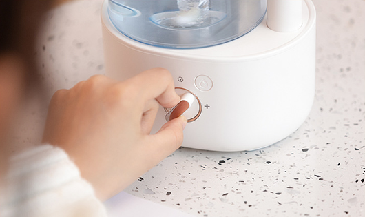 White and clear humidifier with a visible water vortex, emitting mist, and featuring a rose gold accent. - Image 17