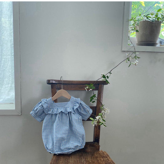 Light blue and white gingham baby romper with puff sleeves and ruffled square neckline, hanging on a wooden chair. - Image 2