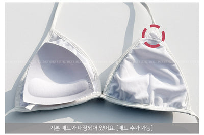 White and black striped bikini with triangle-cut top and tie-side bottom, modeled outdoors. - Image 12