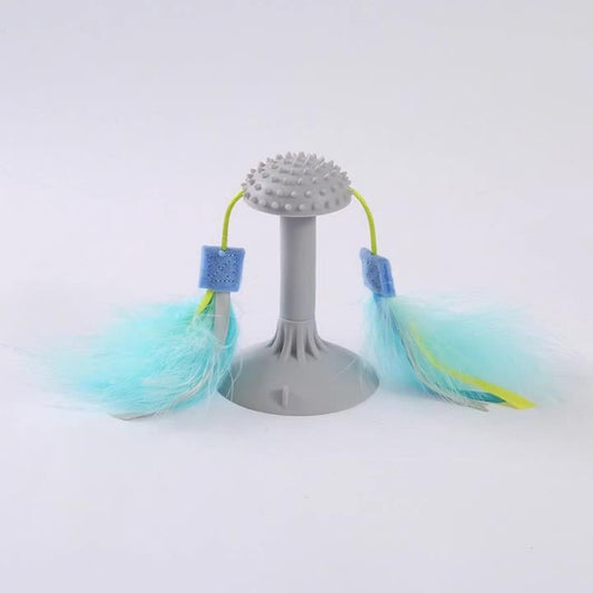 Gray suction cup cat toy with a textured top and two blue and yellow feathered wands attached by green cords.
