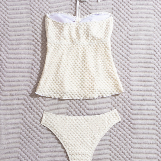 Off-white textured two-piece women's swimsuit with a bandeau halter top and high-cut bottoms, displayed with a straw hat and sunglasses. - Image 2