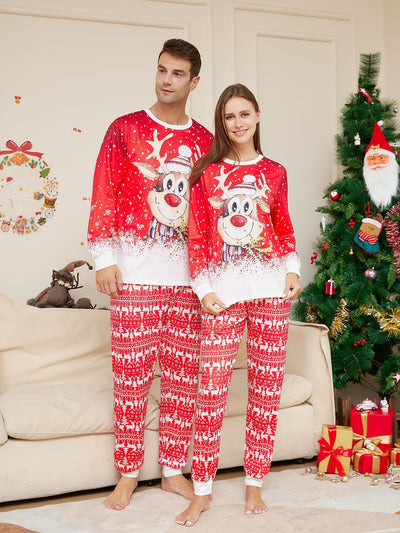 Family of four wearing matching red Christmas pajamas with reindeer and snowflake patterns, sitting on a sofa. - Image 9