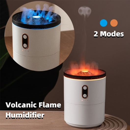White volcanic flame aroma essential oil diffuser emitting orange light and mist on a wooden desk next to a laptop.