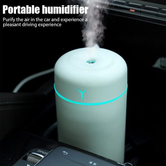 Pink portable humidifier with a blue LED light band, emitting fine mist, on a white pedestal. - Image 15