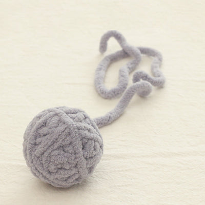 Colorful plush yarn ball cat toy in pink, blue, and white, with a long trailing strand, on a light background. - Image 21