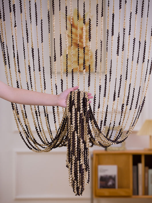 Brown and beige striped string curtain with twisted tassel texture, held by a hand, for living room partition. - Image 6