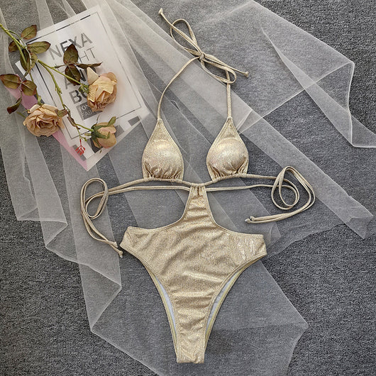 Woman wearing a shimmering gold one-piece swimsuit with a halter neck, crisscross straps, and stylish cut-out details. - Image 11