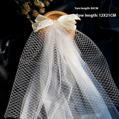 White birdcage veil with a cream satin bow and faux pearls, attached to a woven straw base, 80cm yarn length. - Image 20