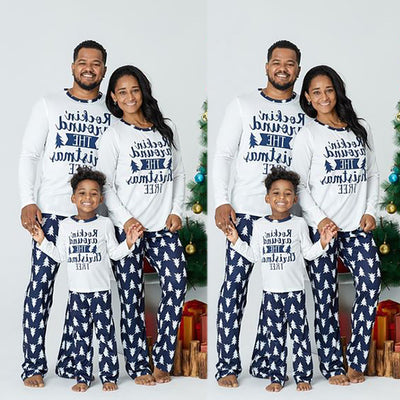 Family of three wearing matching white and navy blue Christmas pajamas with "Rockin' around THE Christmas TREE" text. - Image 5