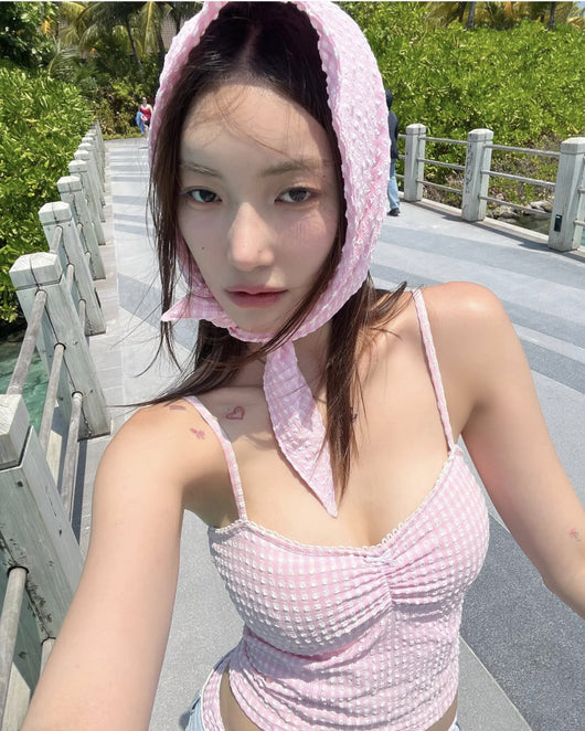 Woman in a blue and brown plaid two-piece swimsuit with a matching headscarf and sunglasses, holding a fluffy object. - Image 18
