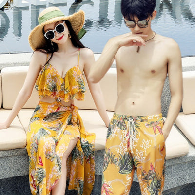 Pink tropical print three-piece women's swimwear set with ruffled bikini top, high-waisted bottoms, and matching sarong.