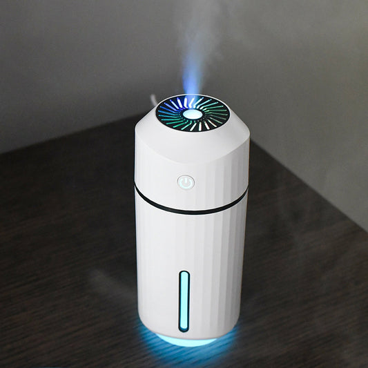 Pink columnar mini car humidifier with a power button and a clear water level indicator on a white background.