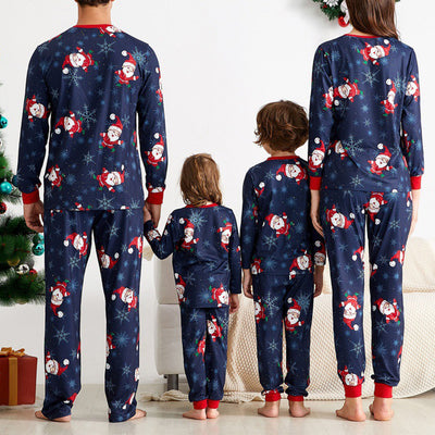 Family of four wearing matching red and white Christmas pajamas with reindeer and snowflake patterns, sitting with gifts. - Image 10