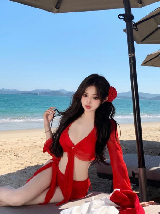 Red four-piece bikini set with sheer long-sleeve tie-front top and matching tie-front skirt on a beach. - Image 15